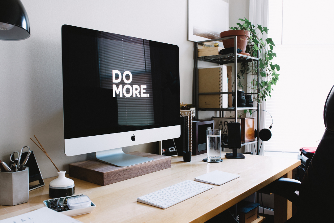 Photo of a computer on a desk displaying the words 'DO MORE'